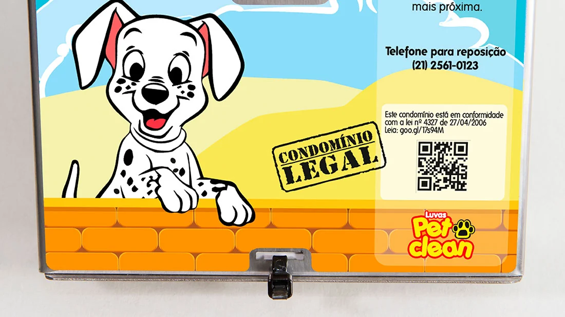 O painel do Dispenser Pet Clean visto de perto, com o telefone para reposição, o aviso de conformidade com a lei e o selo Condomínio Legal.